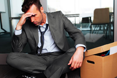 vaccine-exemptions-terminated image of man slumped over by boxes after being terminated by employer