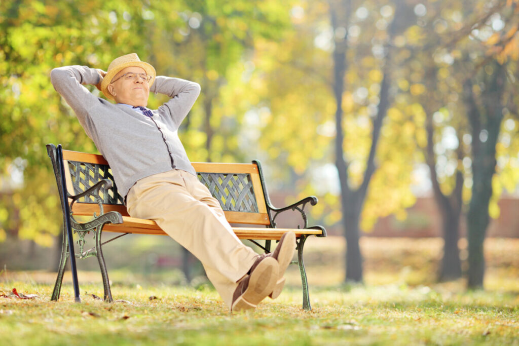 Older gentleman relaxing on a bench in a park