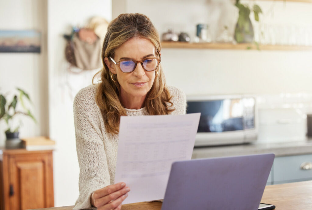 Mature woman at her laptop reading a document.