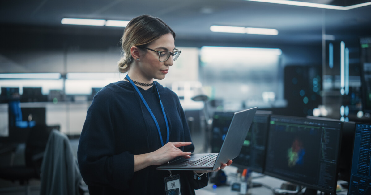 Tech employee on a laptop in a workplace.