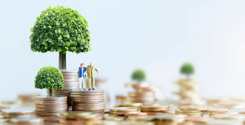 Miniature Elderly people standing on stack of coins.