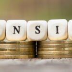 The letters PENSION on top of small stacks of coins