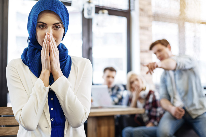 image of woman with cultural attire being excluded from work group by workplace discrimination