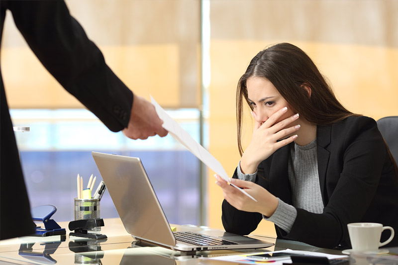 image of upset woman receiving wrongful termination notice