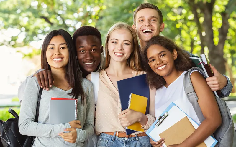 image of diverse group of smiling college students who could need changes and extensions of status to their immigration