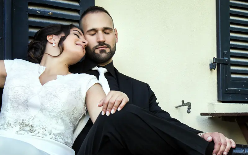 image of a just married couple relaxing outside quaint building