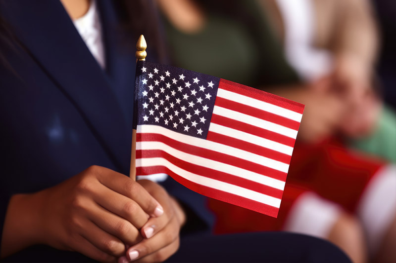 image of immigrant holding flag at naturalization ceremony