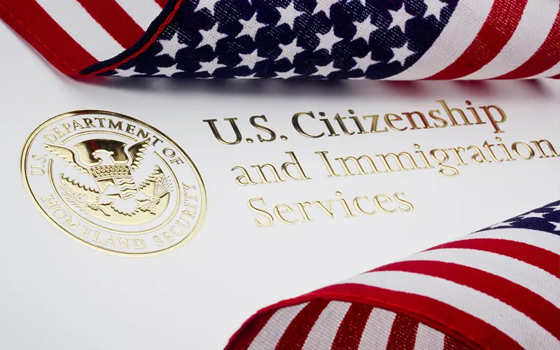 image of american flags on a gold U.S. citizinship and immigration services emblem