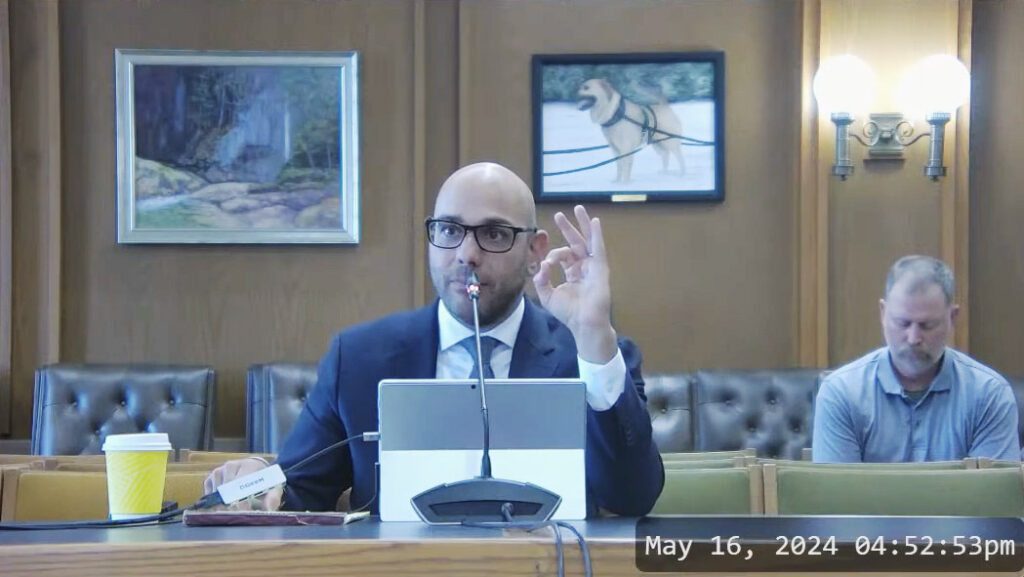 video overlay image of aaron siri testifying at the new hampshire house committee