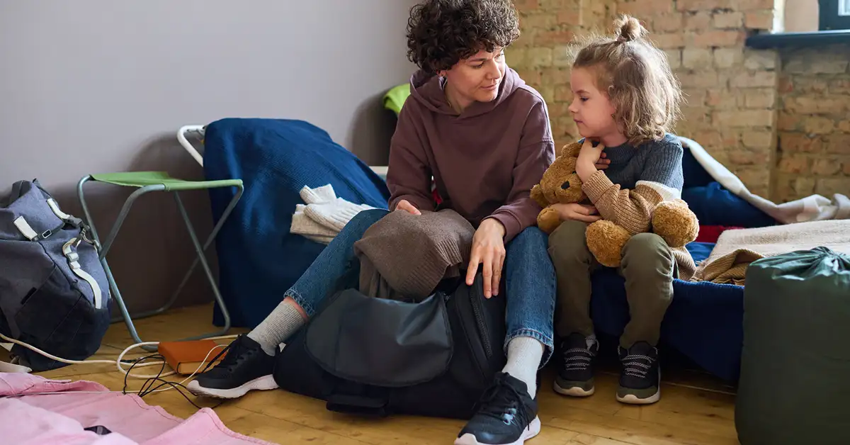 image of woman and young female child sitting in a shelter, representing USCIS keeping families together program