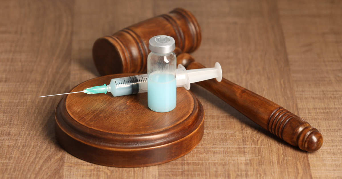 image of gavel with vaccine vial and syringe on it, representing the vaccine injury court