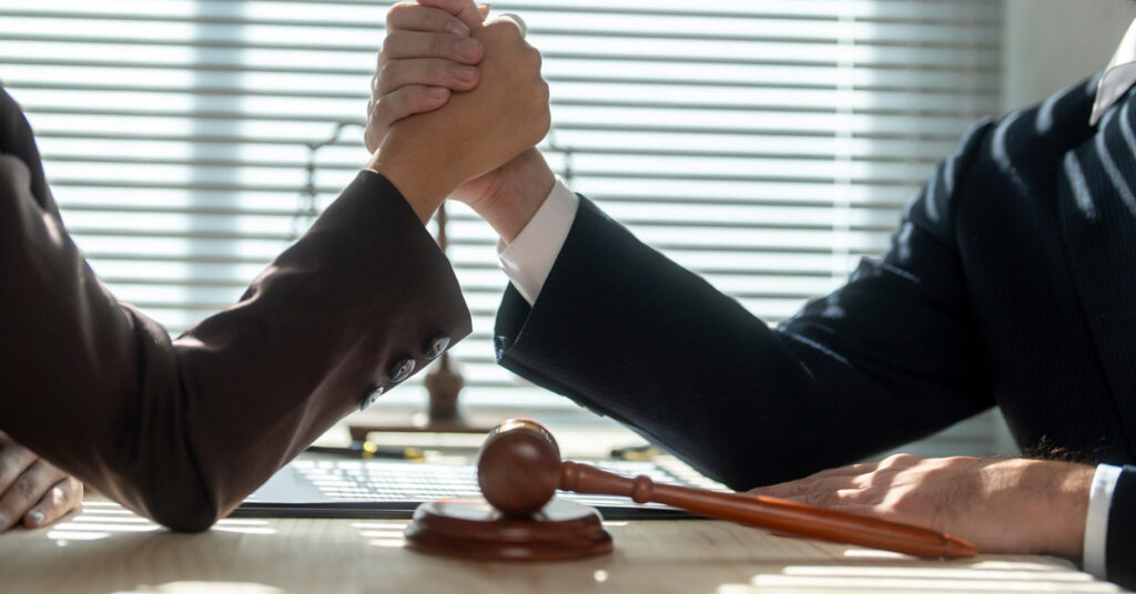image of lawyers arm wrestling representing vaccine injury lawyers vs personal injury lawyers