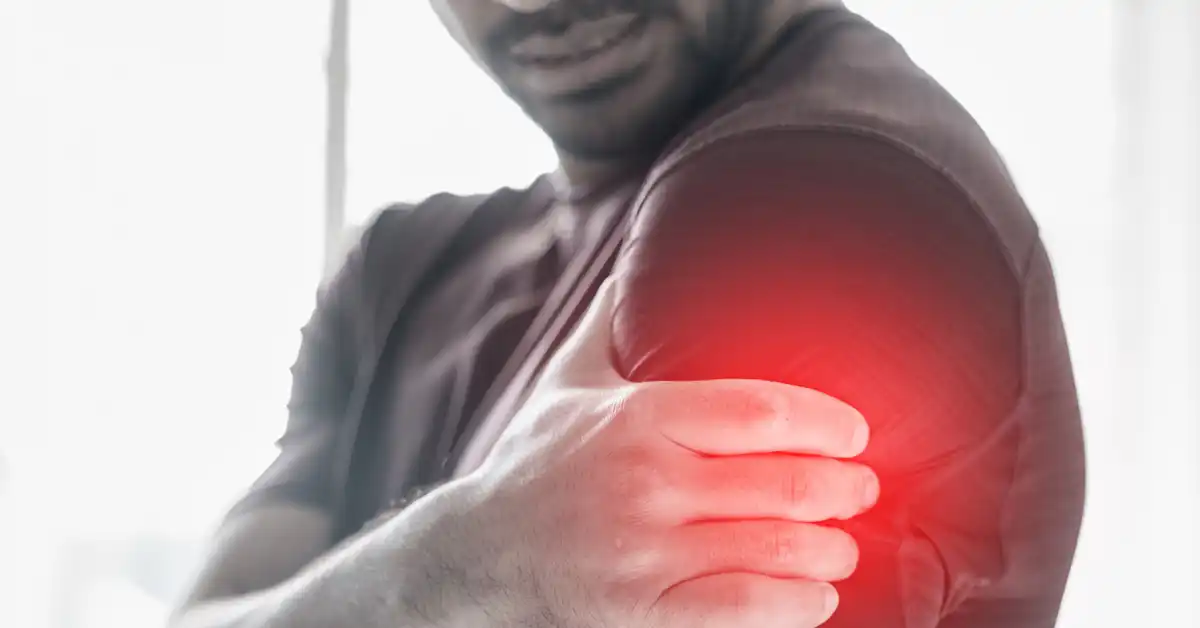 sepia image of a man grabbing his shoulder with sirva pain with red highlight illustrating the pain