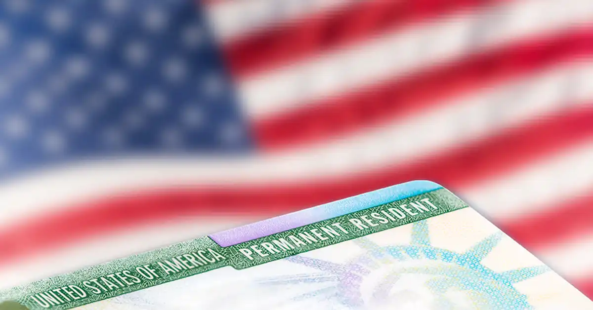 image of permanent resident card in front of american flag representing us naturalization