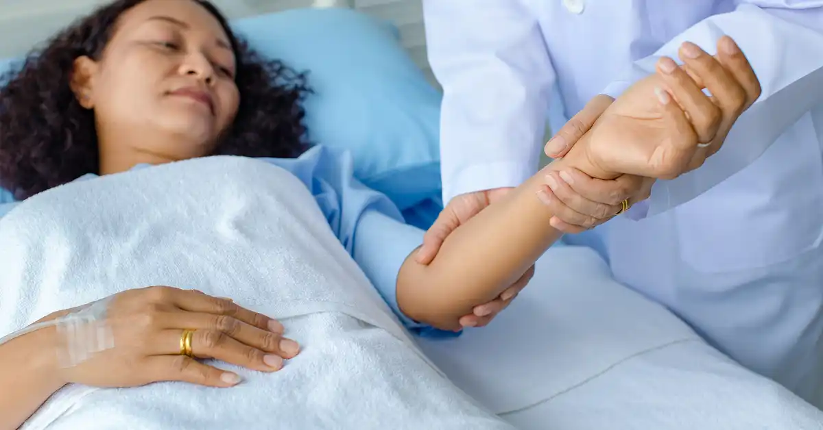 image of woman in hospital bed with doctor examining her forearm used for representing Guillain-Barré Syndrome