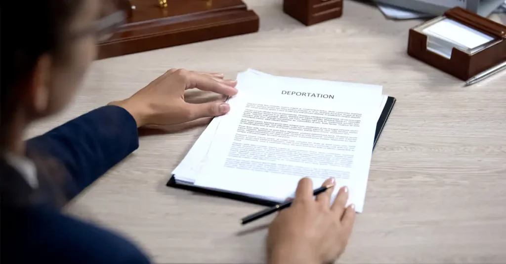 image of lawyer at desk with deportation document in front of her, representing the risk of deportation