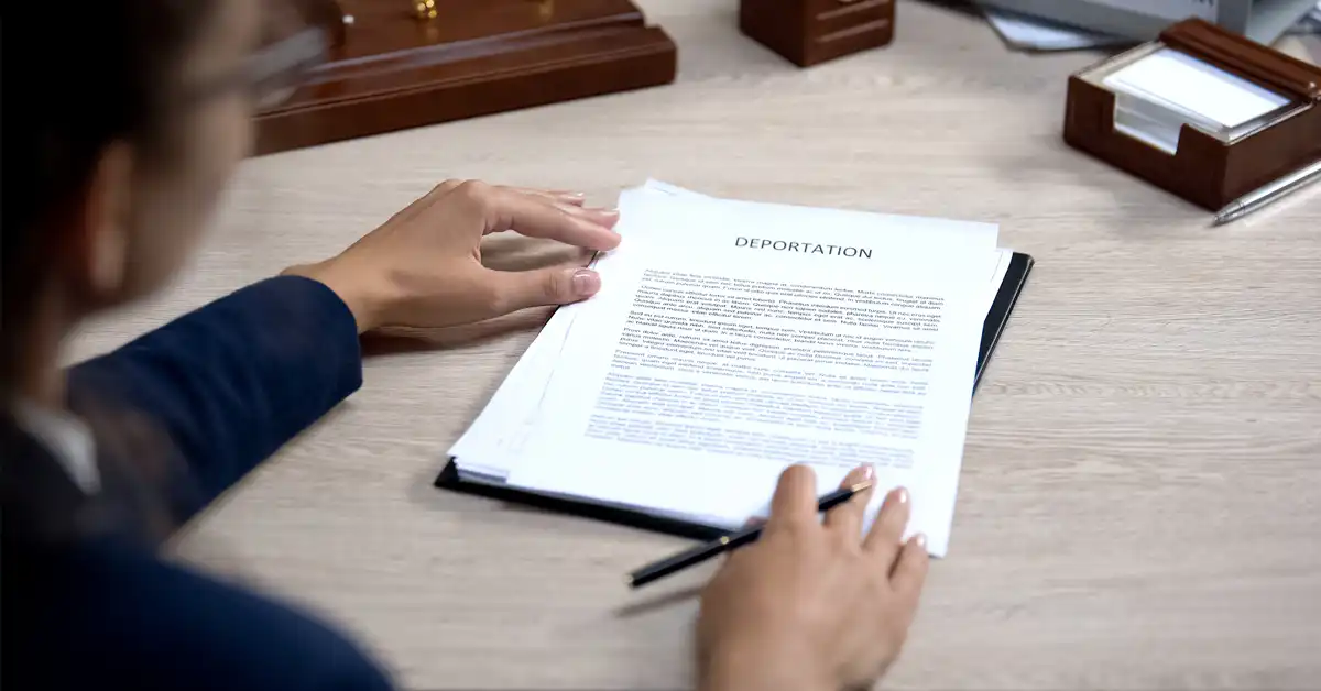 image of lawyer at desk with deportation document in front of her, representing the risk of deportation