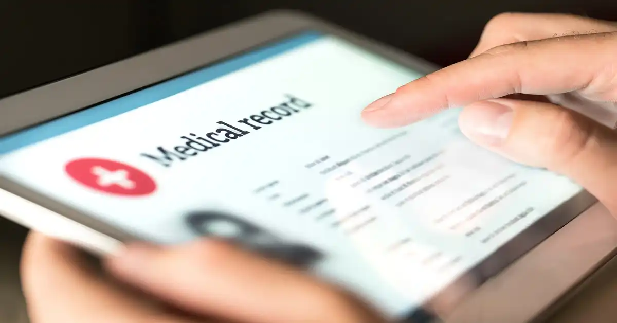 image of a tablet being held with medical records as the title on the screen