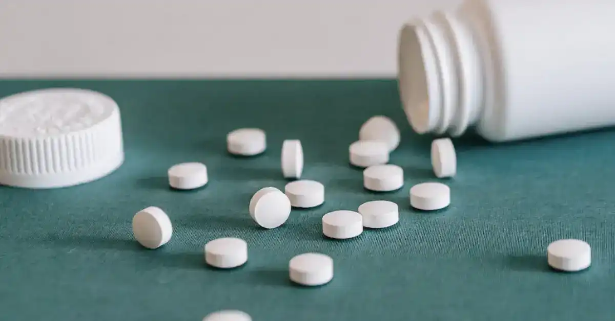 image of a bottle of pills tipped over with pills on the counter