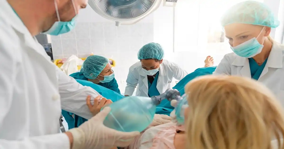 image of woman in hospital surrounded by doctors giving birth representing uterine rupture during childbirth