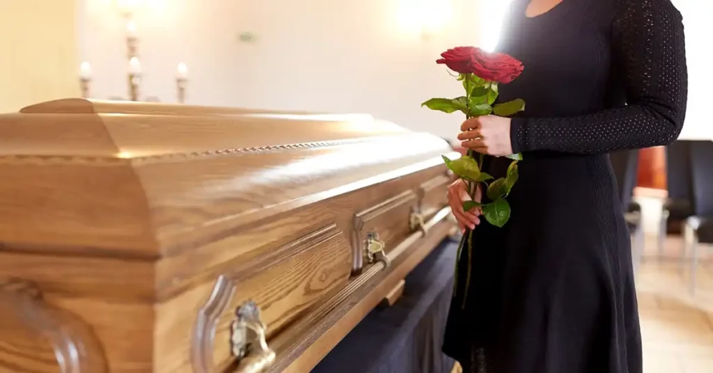 image of a woman in black dress holding flowers by a casket representing wrongful death