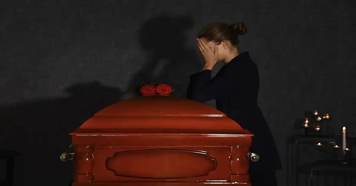 image of woman with hands on her face leaning on a casket representing wrongful death