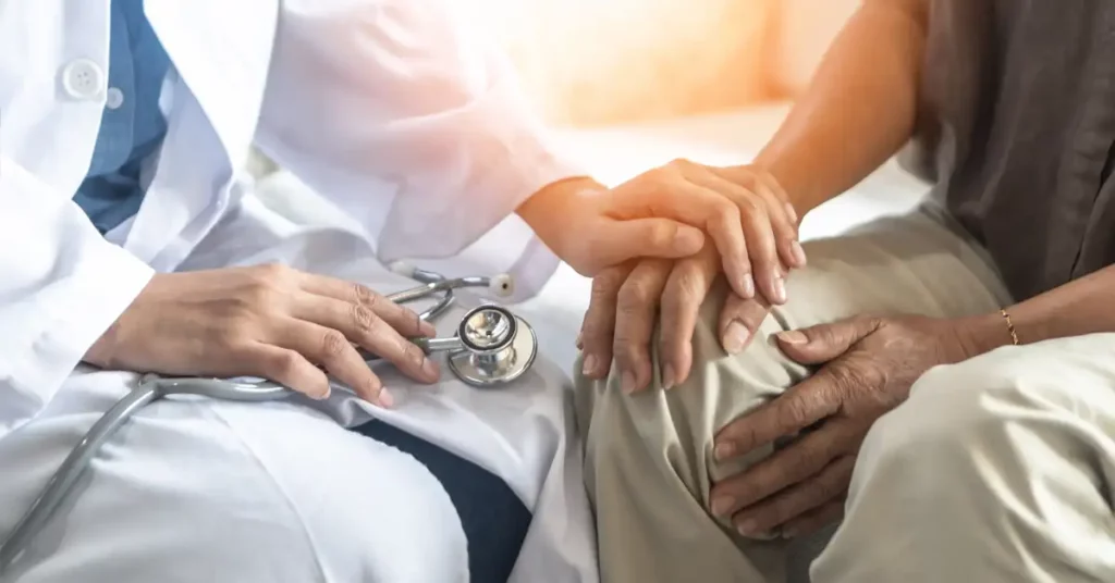image of doctor consulting patient with hand on knee