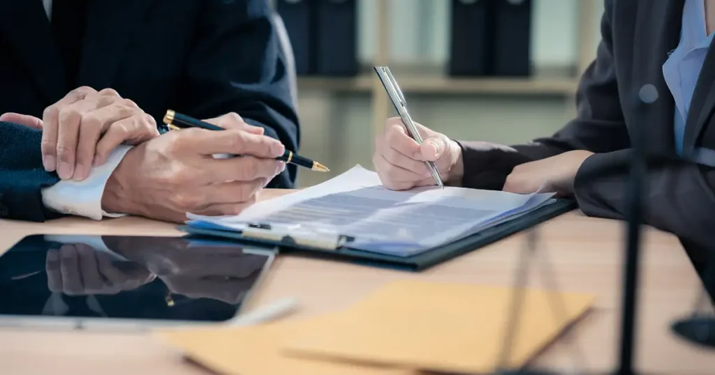 In a law office setting, a team of professional attorneys is diligently reviewing medical documents, likely related to vaccine injury claims. The scene reflects a serious atmosphere as they prepare to represent clients affected by vaccine-related injuries in federal claims and the national vaccine injury compensation program.