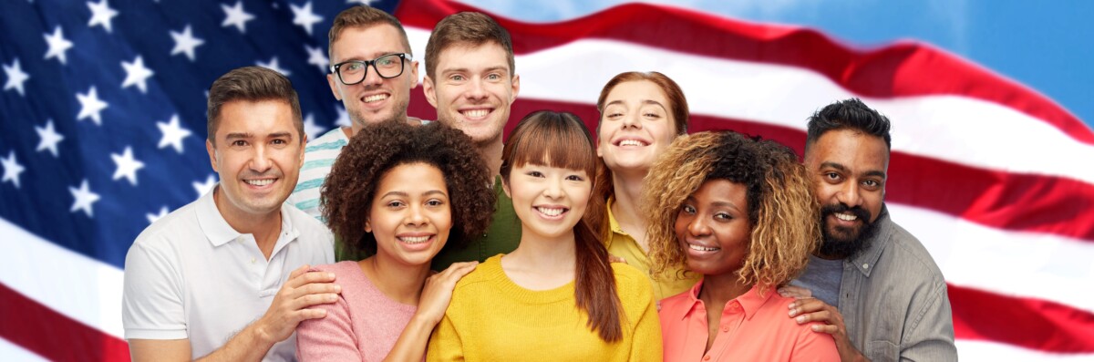 Multinational group representing employment and family-based immigration clients standing in front of the American flag