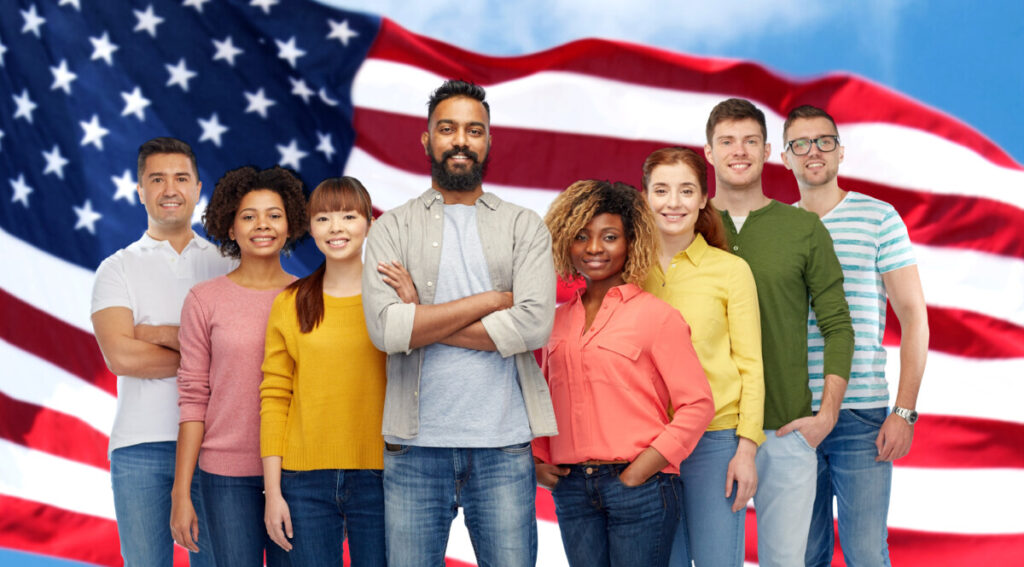 Diverse professionals in front of an American flag — illustrating USCIS H-1B visa applicants and $100,000 fee exemptions