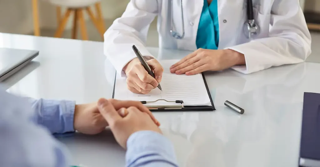 A medical professional is focused on reviewing a patient's records and vaccination documentation, likely assessing vaccine-related injuries to determine eligibility for the vaccine injury compensation program. This process involves examining medical records and the causal relationship between vaccinations and adverse events to support potential claims in the federal court system.