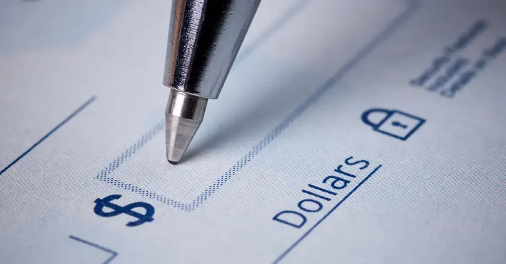 Close-up of a check being written, symbolizing financial compensation available through vaccine injury claims
