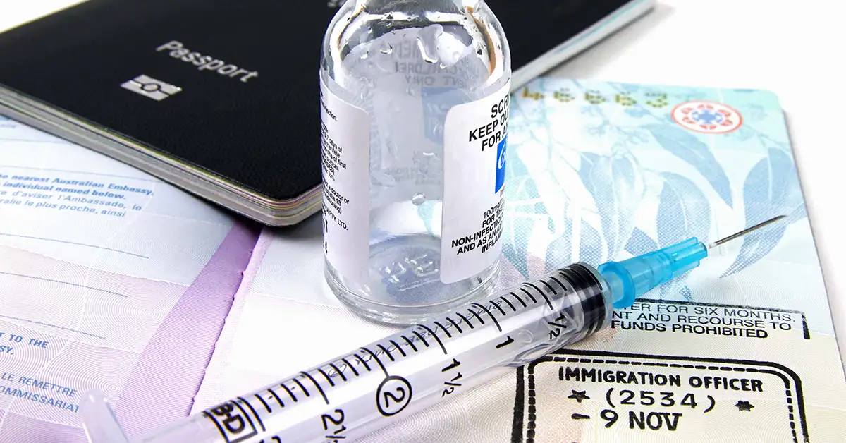 Passport and visa documents next to a medical vial and syringe, representing vaccination and documentation matters handled by immigration attorneys.