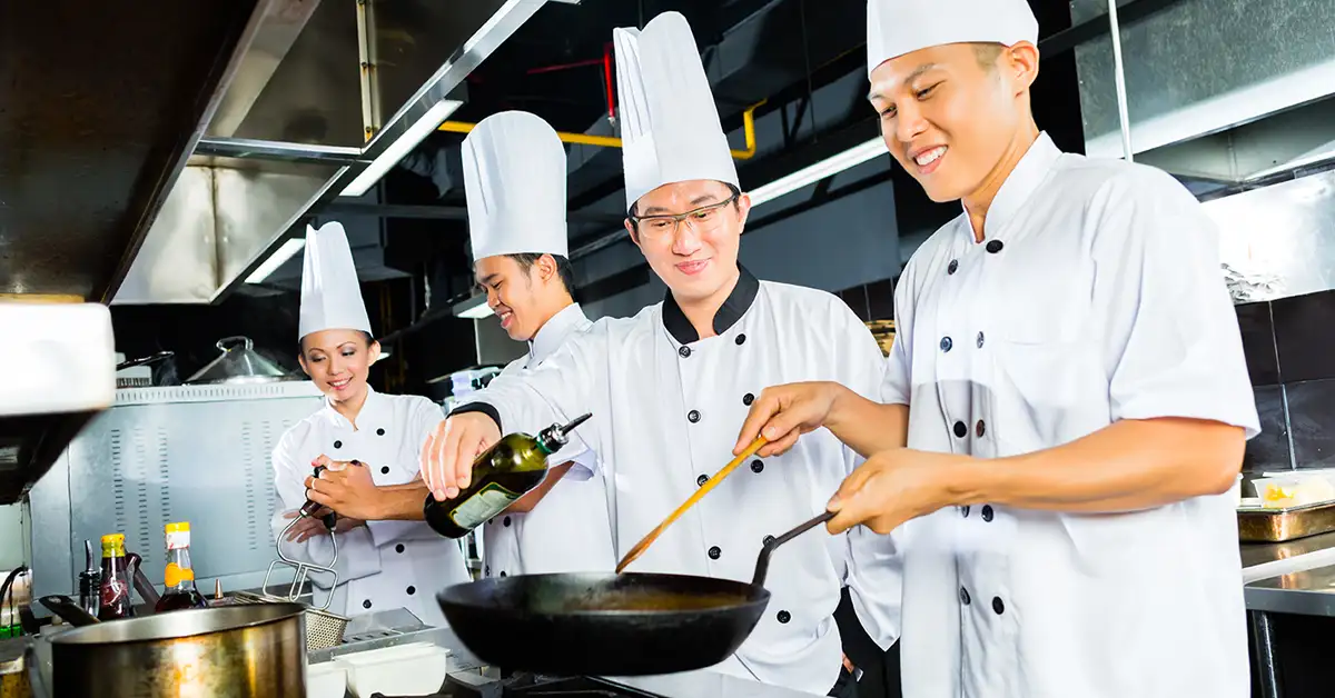 Chefs collaborating in a professional kitchen, illustrating employment-based immigration situations assisted by immigration attorneys.