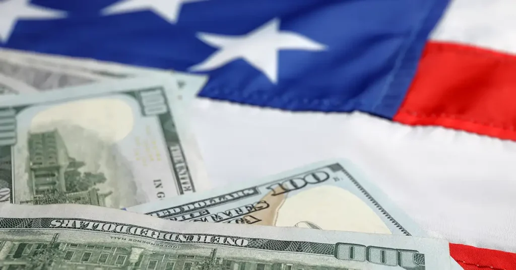 U.S. dollar bills on an American flag, illustrating immigration fees and financial requirements immigration attorneys help clients navigate.