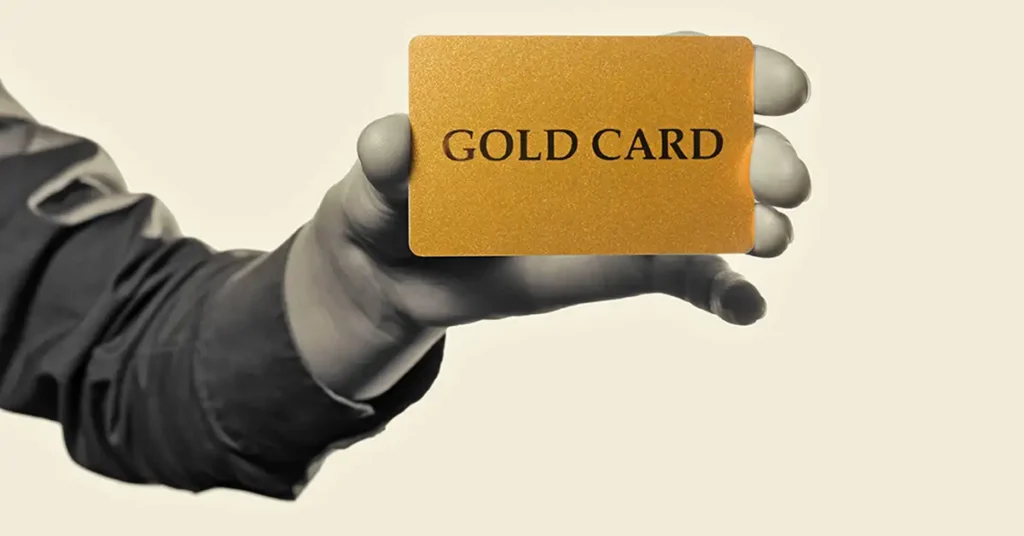 A hand holding a card labeled “Gold Card,” representing immigration status and documentation issues addressed by immigration attorneys.