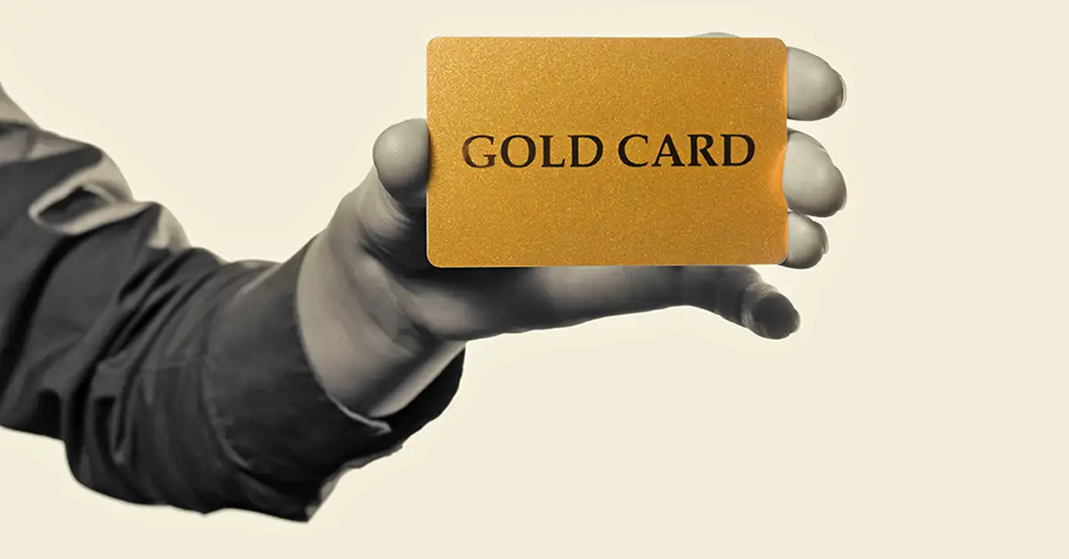 A hand holding a card labeled “Gold Card,” representing immigration status and documentation issues addressed by immigration attorneys.
