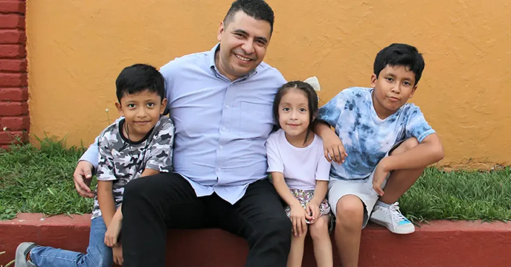 A father seated with his children outdoors, representing family-based immigration matters assisted by immigration attorneys.