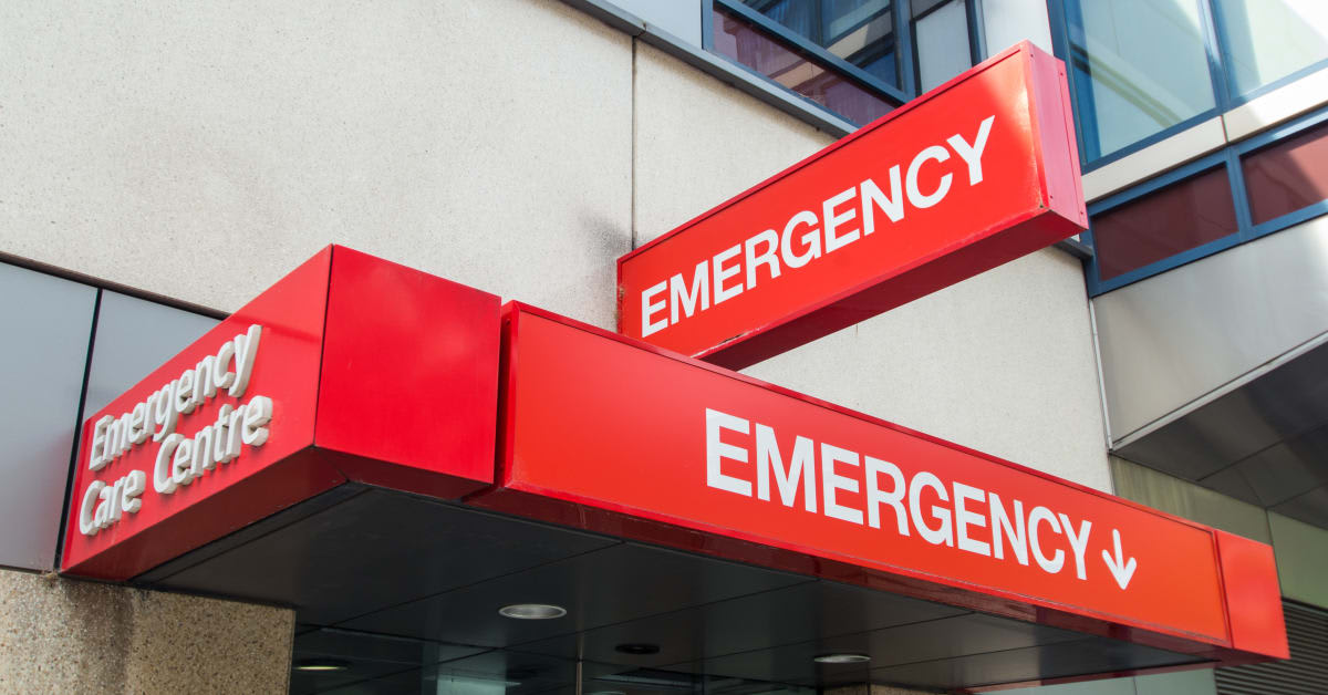 Hospital patient lying in bed with oxygen tube and heart monitor in background