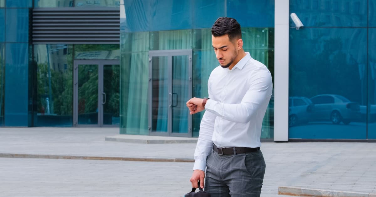 A man checking his watch while holding a briefcase, reflecting time-sensitive immigration appointments managed by immigration attorneys.