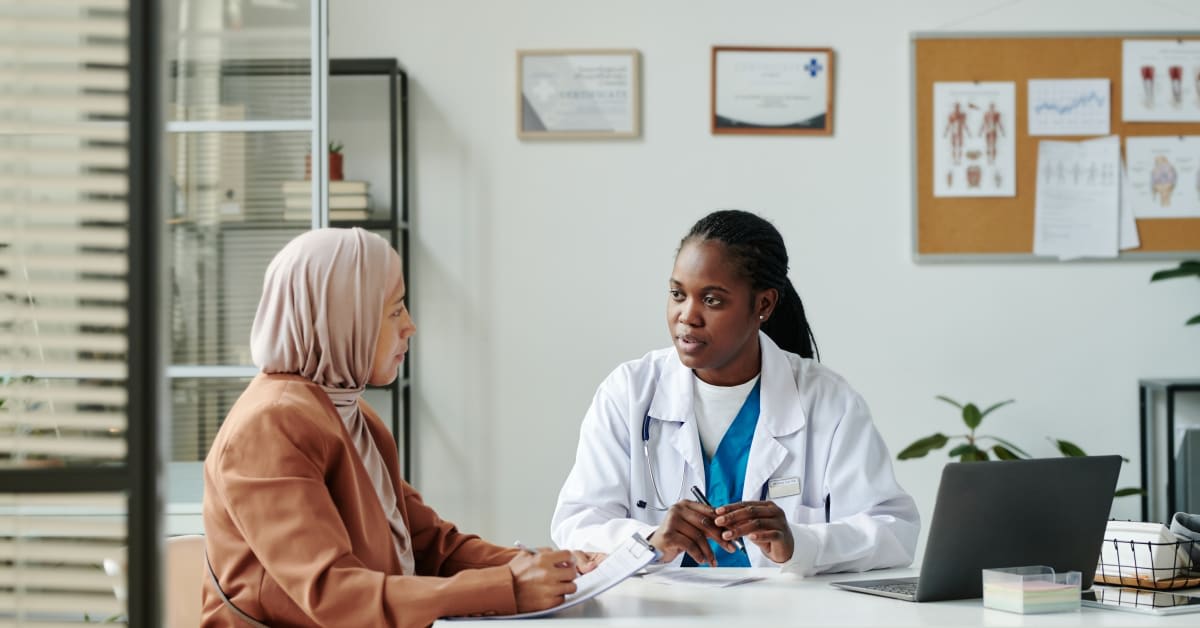A doctor speaking with a patient in a clinic, reflecting immigration medical exam issues addressed by immigration attorneys.