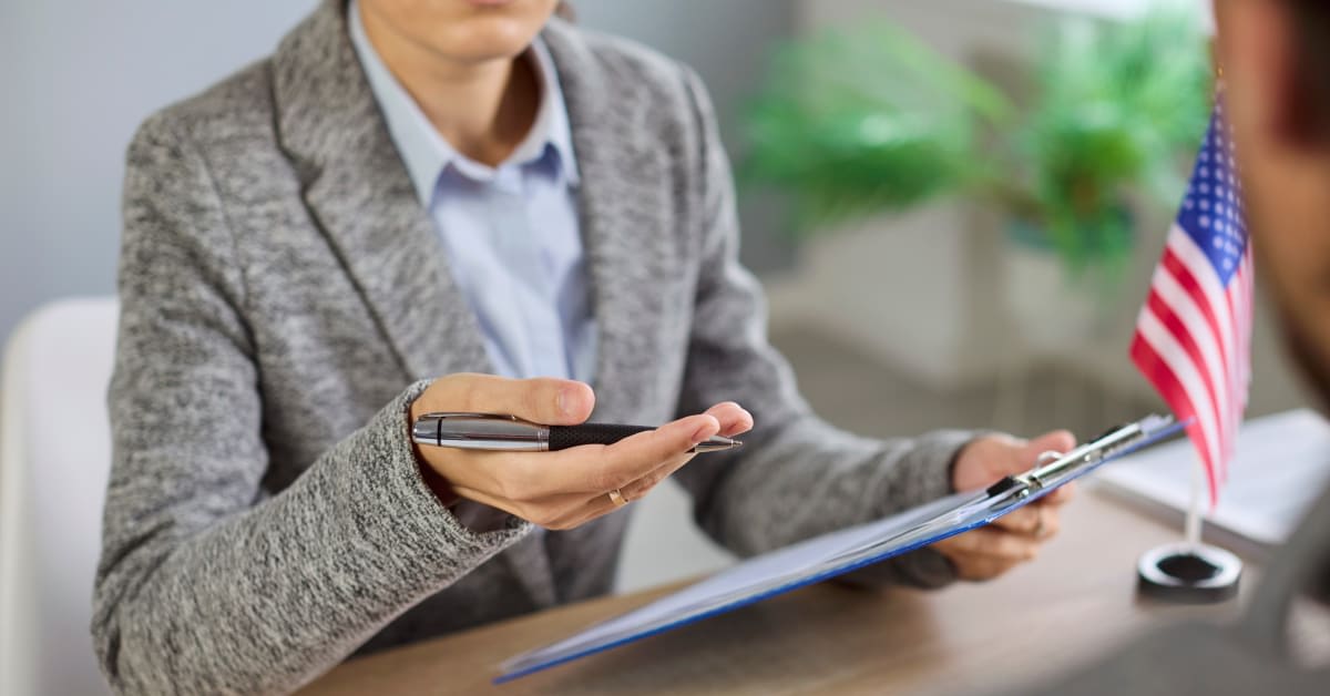 immigration-interview A person reviewing a form on a clipboard in an office setting, reflecting immigration interviews supported by immigration attorneys.