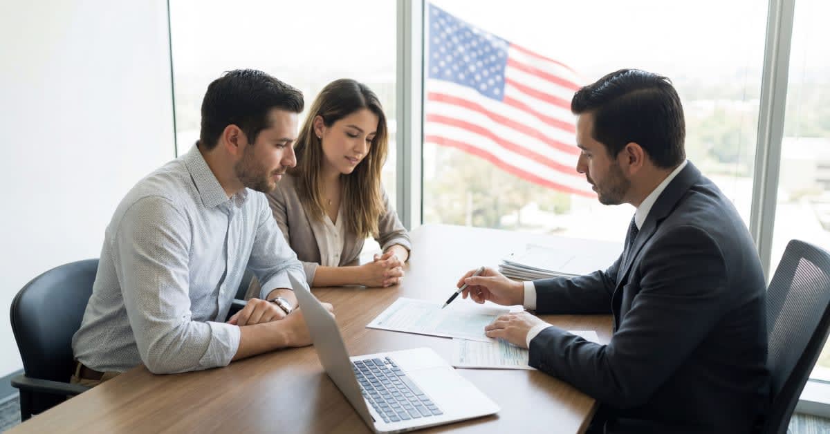 An attorney meeting with clients at a desk, representing immigration legal guidance provided by immigration attorneys.