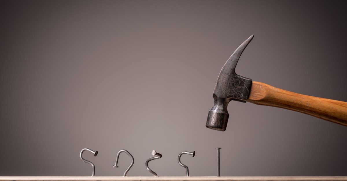 A hammer knocking down hooks spelling “mistakes,” reflecting immigration errors immigration attorneys help clients avoid.