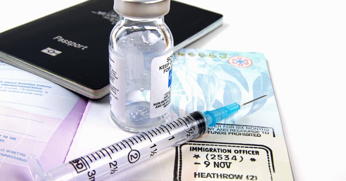 Passport and visa documents beside a medical vial and syringe, representing vaccination-related immigration requirements handled by immigration attorneys.
