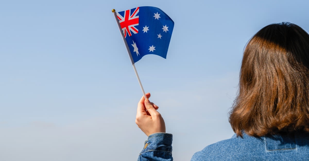 A person holding an Australian flag, reflecting country-specific visa issues addressed by immigration attorneys.