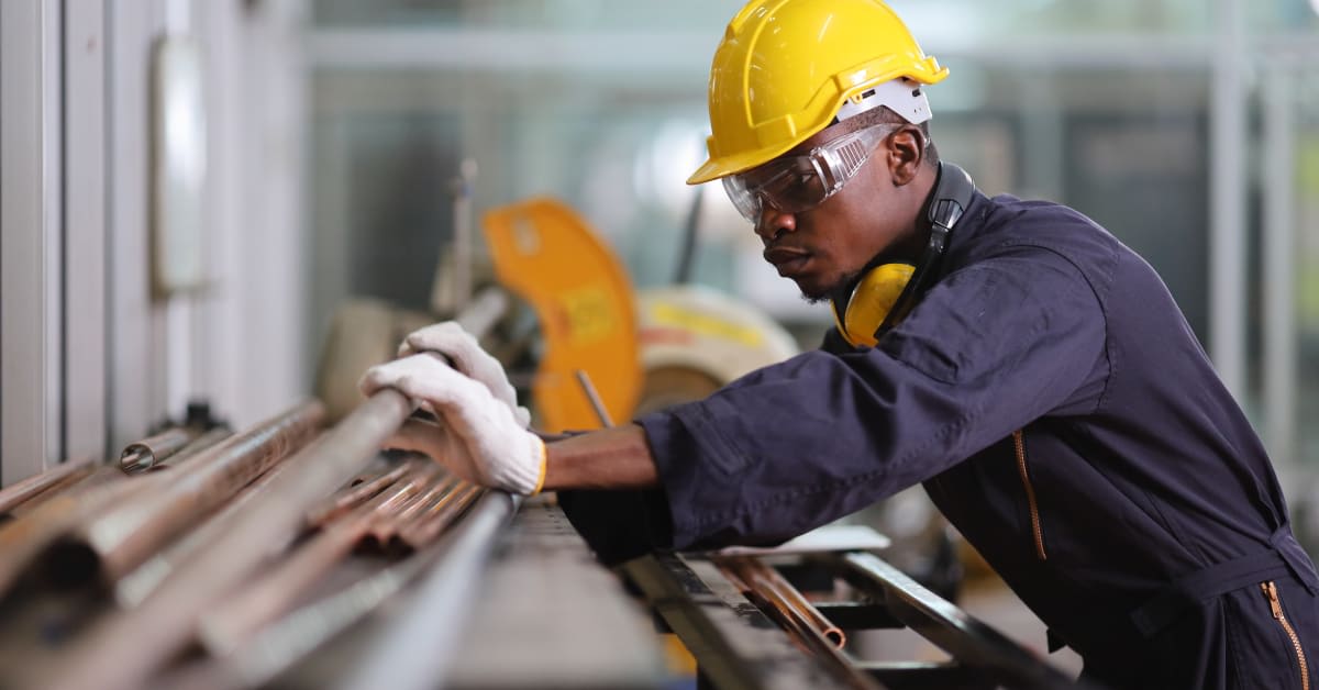 Construction worker handling materials at a job site, representing work restrictions immigration attorneys help visitor visa applicants understand.
