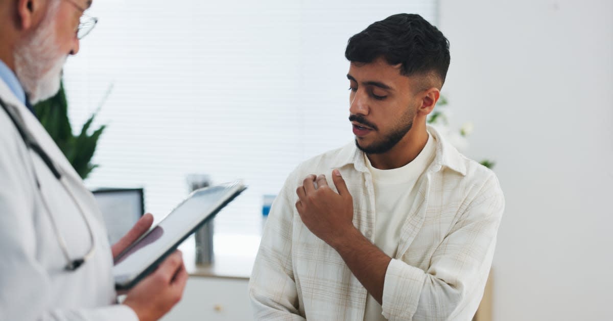 Doctor evaluating a patient with shoulder pain during a medical examination for symptoms that may be consistent with a vaccine-related shoulder injury