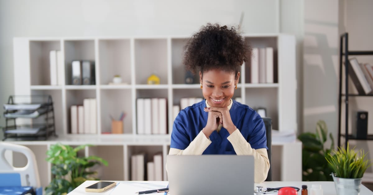 Healthcare professional using laptop, employee vaccine exemption assistance