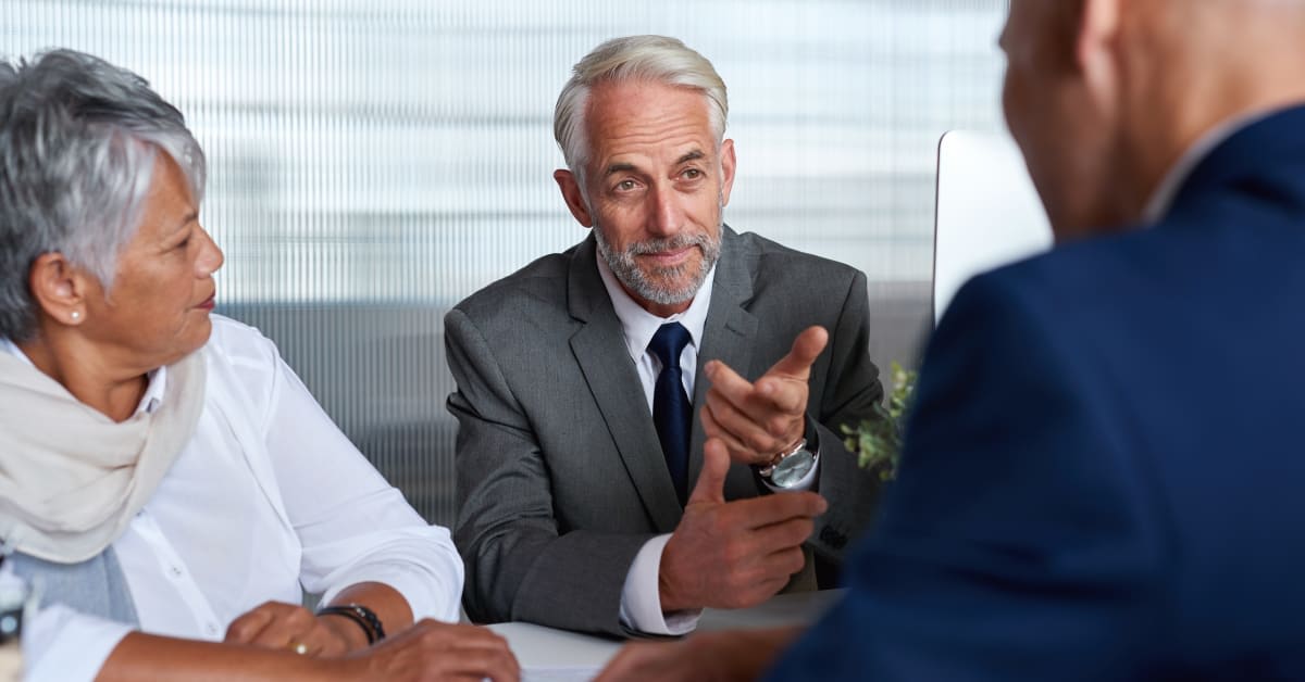 Business professionals meeting at a conference table, representing investor visa matters assisted by immigration attorneys.